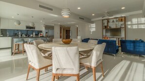 A modern kitchen with a central island, bar stools, and a dining table with chairs. - 4,198ft² Oceanfront Presidential Suite · Jacuzzi Terrace · Butler · Sleeps 8 (B.C.S.)