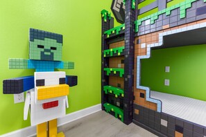 A room with a green wall, a bed with a white mattress, and a wall-mounted shelf with a green and black design. - Themed 9BR Villa, Pool, Game Room, Champions Gate (Davenport)