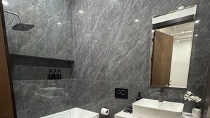 Ein modernes Badezimmer mit Badewanne, Toilette und Waschtisch mit Spiegel.