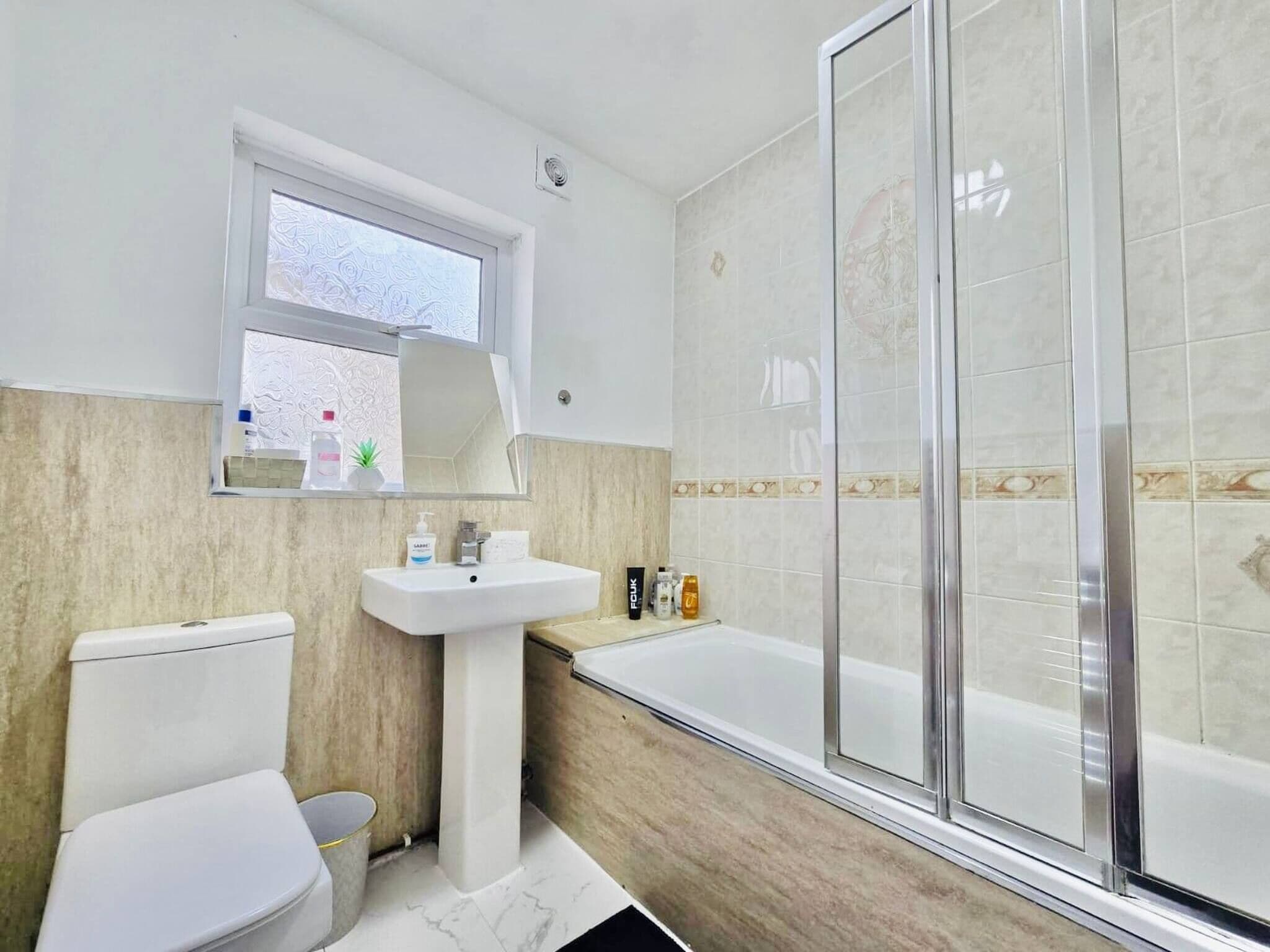 Un baño con inodoro, lavamanos y ducha.
