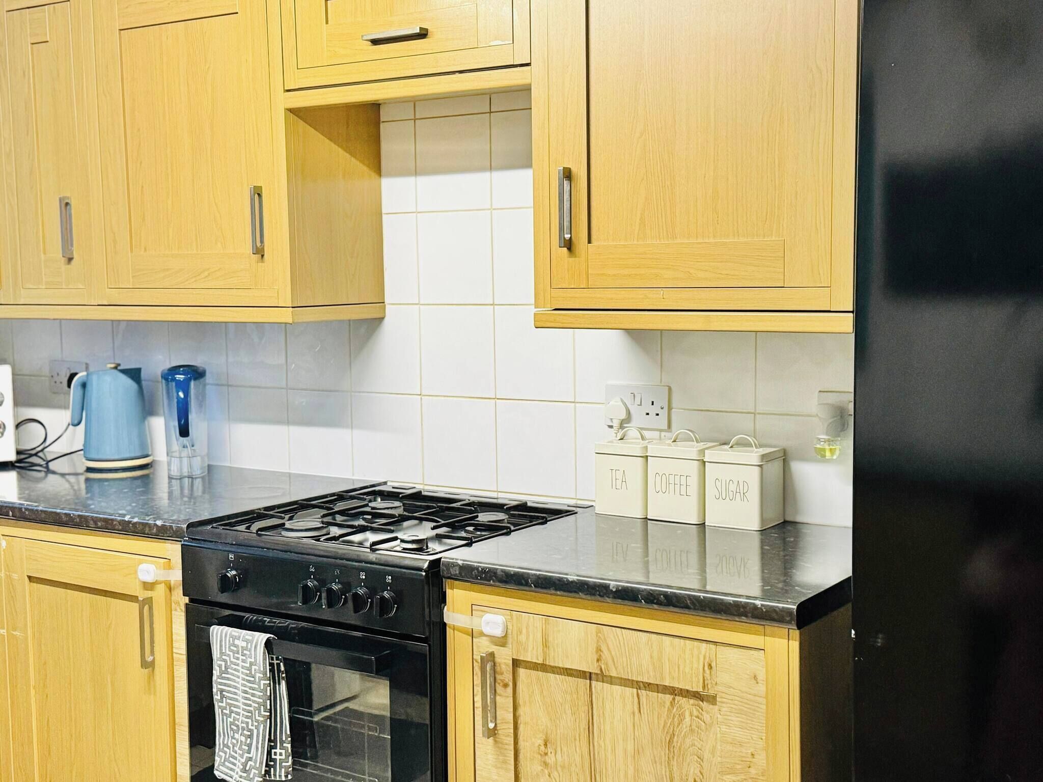 A kitchen with wooden cabinets, a gas stove, and a refrigerator.