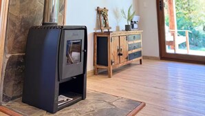 Ein modernes Interieur mit Wandverkleidung aus Stein, einem Kamin, einem an der Wand befestigten Fernseher und einem Holzschrank.