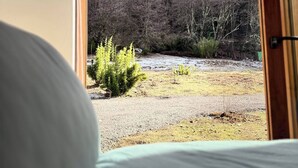 A room with a bed, a window, and a view of a forested hillside. - Casa para 8 Personas a solo 5 km de Corralco (Malalcahuello)