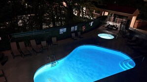 A swimming pool with a ladder, lounge chairs, and a hot tub area. - Downtown Gatlinburg-Bear View Manor-Update - Renovated-near Convention Center (Gatlinburg)