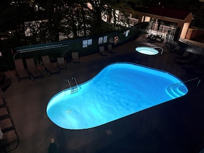A swimming pool with a ladder, lounge chairs, and a hot tub area. - Downtown Gatlinburg-Bear View Manor-Update - Renovated-near Convention Center (Gatlinburg)