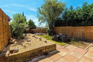 A backyard with a gravel area, a wooden fence, and outdoor furniture. - *NEW* 3BR Home | Driveway | Garden | Pool Table (West Midlands)