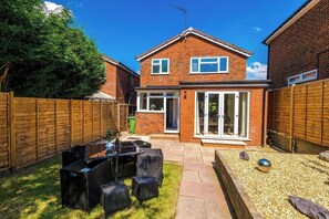 A two-story brick house with a patio area, outdoor seating, and a fenced backyard. - *NEW* 3BR Home | Driveway | Garden | Pool Table (West Midlands)
