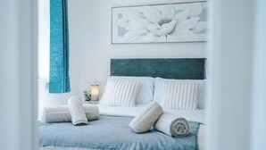 A bedroom with a bed, pillows, a blanket, and a wall-mounted artwork. - *NEW* 3BR Home | Driveway | Garden | Pool Table (West Midlands)