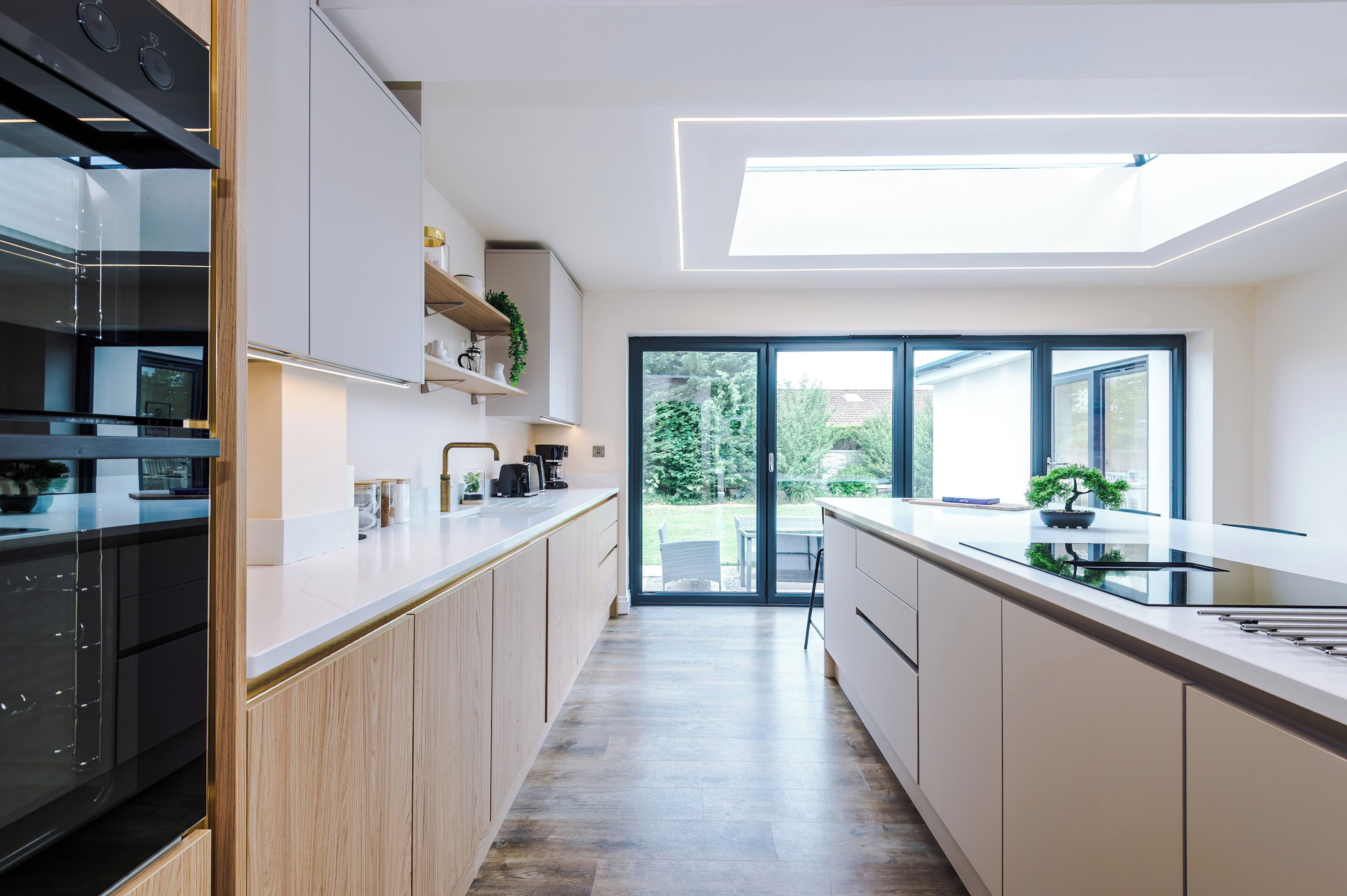 A modern kitchen with a central island, built-in appliances, and a view to the outdoors.