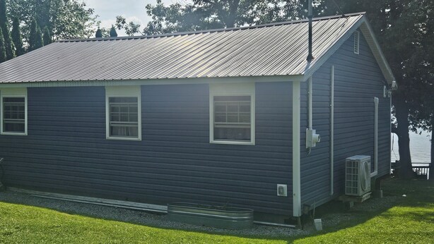 A single-story house with a gabled roof, a front porch, and a small attached garage. - Relaxing Willsboro Waterfront Cottage (Willsboro)