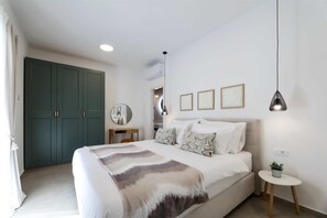 Un dormitorio con cama, mesita de noche, lámpara y armario.