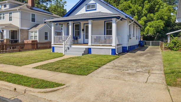 A two-story house with a front porch, a chimney, and a small attached garage. - Charming Del Ray Home, Near Old Town & METRO-rail (Alexandria)