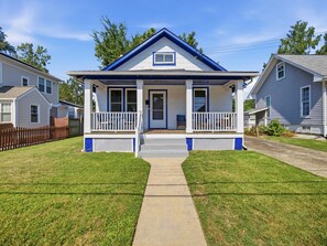 A two-story house with a front porch, a small window above the door, and a visible front yard. - Charming Del Ray Home, Near Old Town & METRO-rail (Alexandria)