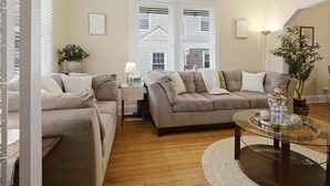A living room with two sofas, a coffee table, and a lamp. - Charming Del Ray Home, Near Old Town & METRO-rail (Alexandria)