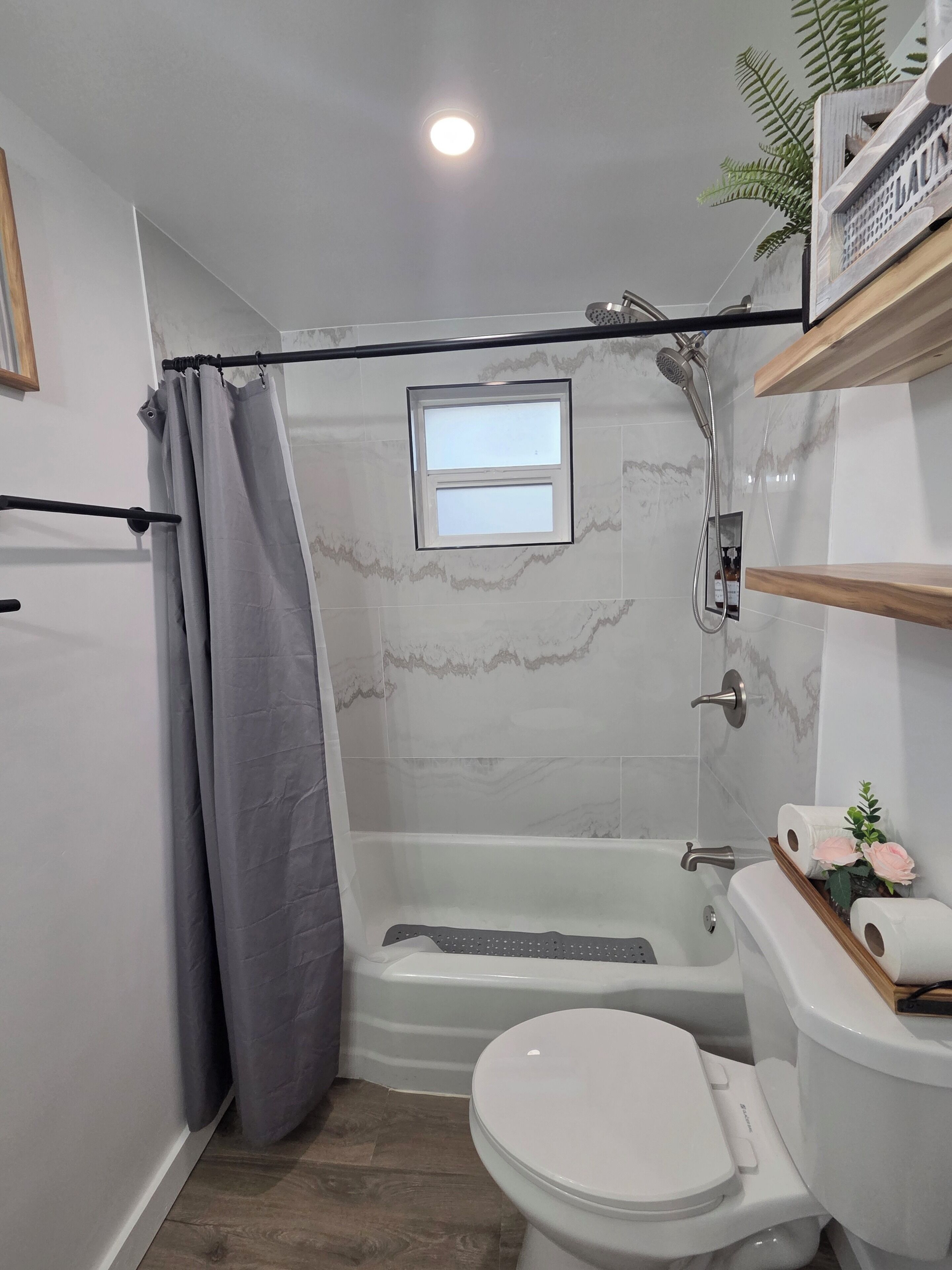 Un baño con ducha, inodoro y bañera.
