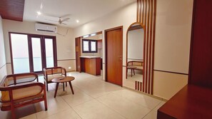 A modern living room with a sofa, a small table, and a TV. - Bliss Giriya By Bergamont (Tiruvannamalai)