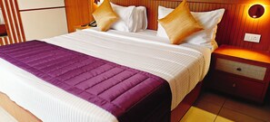 A hotel room with a large bed, a bedside table, and a nightstand. - Bliss Giriya By Bergamont (Tiruvannamalai)