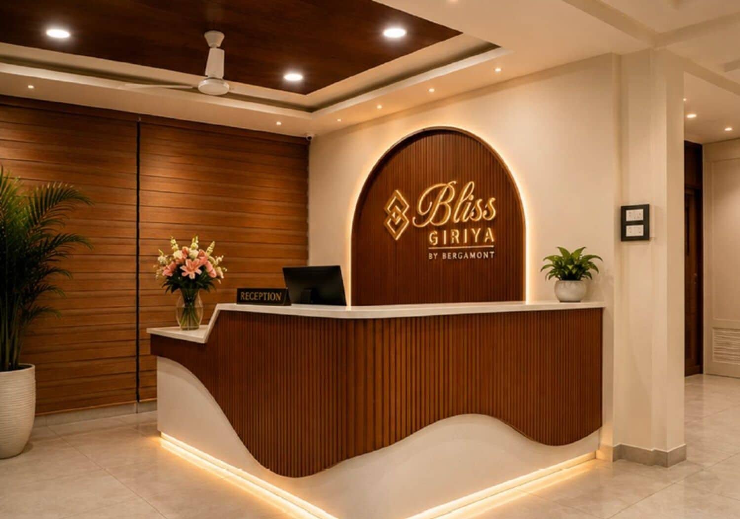 A reception desk with a wooden finish and a logo that reads 'Bliss Giriya by Bergamot.'