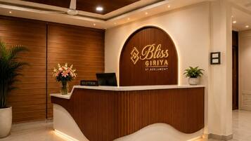A reception desk with a wooden finish and a logo that reads 'Bliss Giriya by Bergamot.'