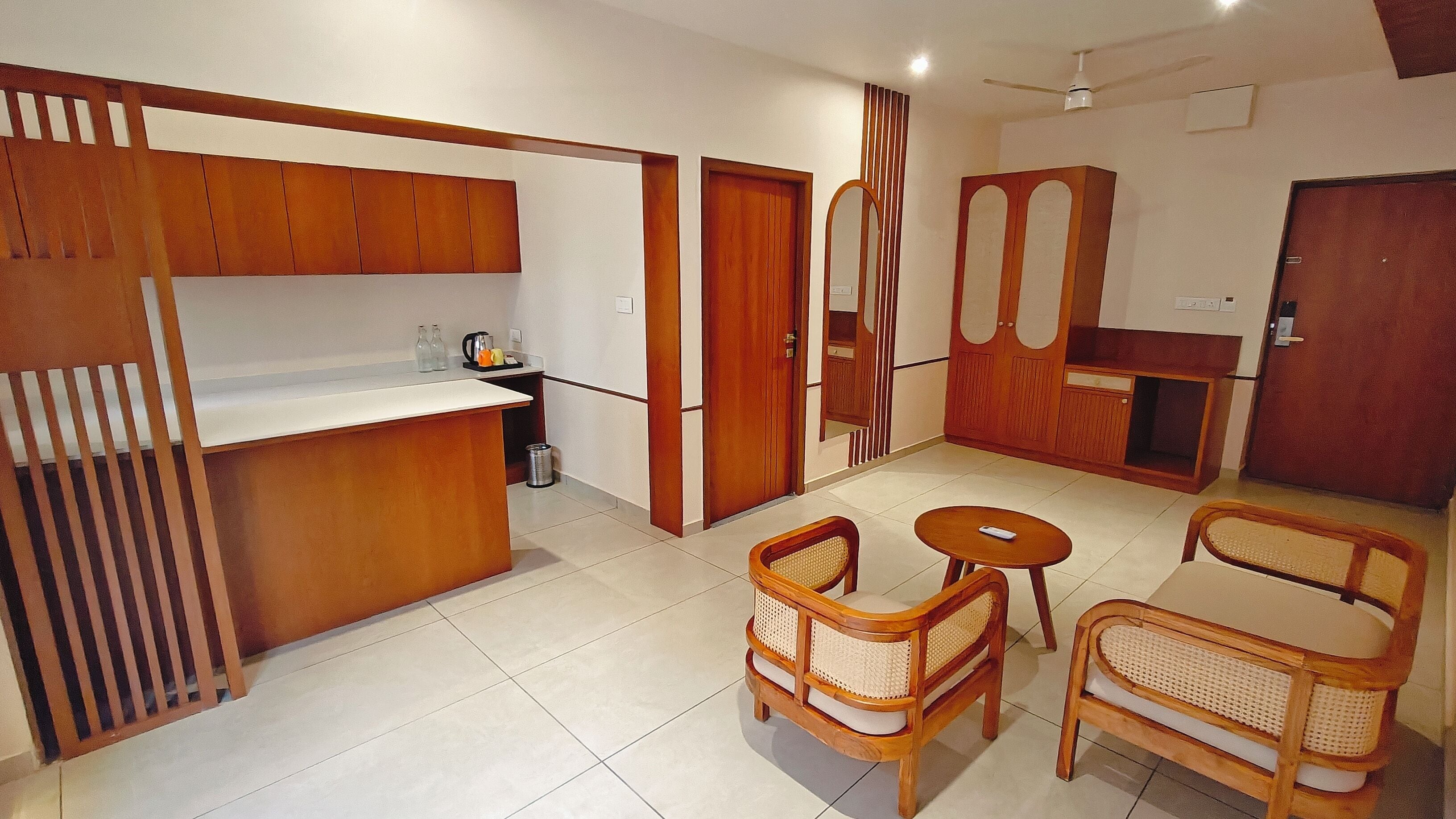 Un espacio habitable compacto con kitchenette, una zona de comedor con dos sillas y una mesita.