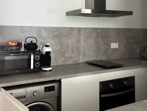 A modern kitchen with a built-in microwave, coffee maker, and kettle. - Sun and Sea Cádiz. Beachfront (Cadiz)