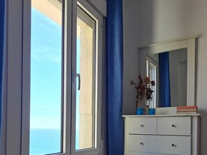A room with a large window, a mirror, and a dresser. - Sun and Sea Cádiz. Beachfront (Cadiz)
