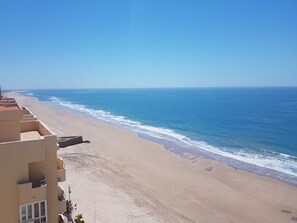 A beach with a building adjacent to it. - Sun and Sea Cádiz. Beachfront (Cadiz)