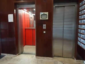 An elevator with a metallic interior and a red wall on one side. - Sun and Sea Cádiz. Beachfront (Cadiz)