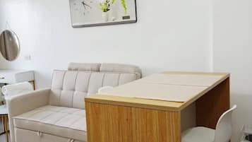 Una sala de estar moderna con un sofá, una mesa de madera y una silla.