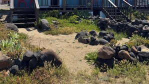 Ein Strandgrundstück mit einer Holzterrasse, einer Treppe und freiem Blick auf den Ozean.