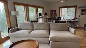 A living room with a sectional sofa, a wooden coffee table, and a bookshelf. - Best View in Fairplay (Fairplay)