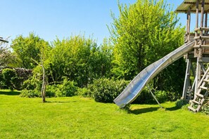 Un parque infantil con un tobogán y una estructura de madera.