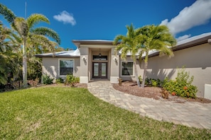 A modern two-story house with a front entrance, a covered patio, and a well-maintained lawn. - Luxury Cape Coral Oasis: Pool, Sleeps 8 (Cape Coral)