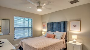 A bedroom with a bed, bedside tables, a ceiling fan, and a window with blinds. - Luxury Cape Coral Oasis: Pool, Sleeps 8 (Cape Coral)