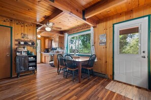 A cabin interior with a dining area, kitchen, and a door with a window. - Mtn Retreat Hot Tub~Lake 20 min (Mi-Wuk Village)