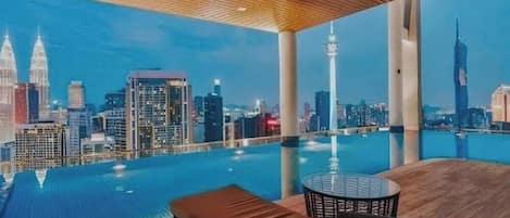 A rooftop infinity pool with a city skyline view, including prominent buildings.