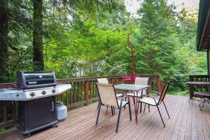 A deck with a grill, chairs, and a table. - Wildwood Snowline Cabin Near Mt Baker (Deming)