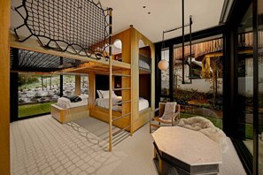 Een modern interieur met een vide, een eethoek en uitzicht op een tuin.