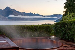 Un jacuzzi con vistas a montañas y un lago.