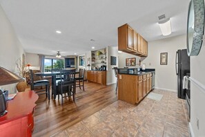 A spacious kitchen with wooden cabinets, a central island, and a dining area with chairs. - Gorgeous 2-bedroom condo with beautiful pool, hot tub, and more in Hot Springs (Hot Springs)