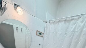 Baño con lavamanos, espejo e inodoro blancos.