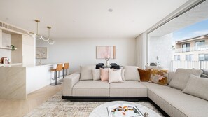 Ein modernes Wohnzimmer mit einer Couch, einem Couchtisch und einem Essbereich mit Stühlen.
