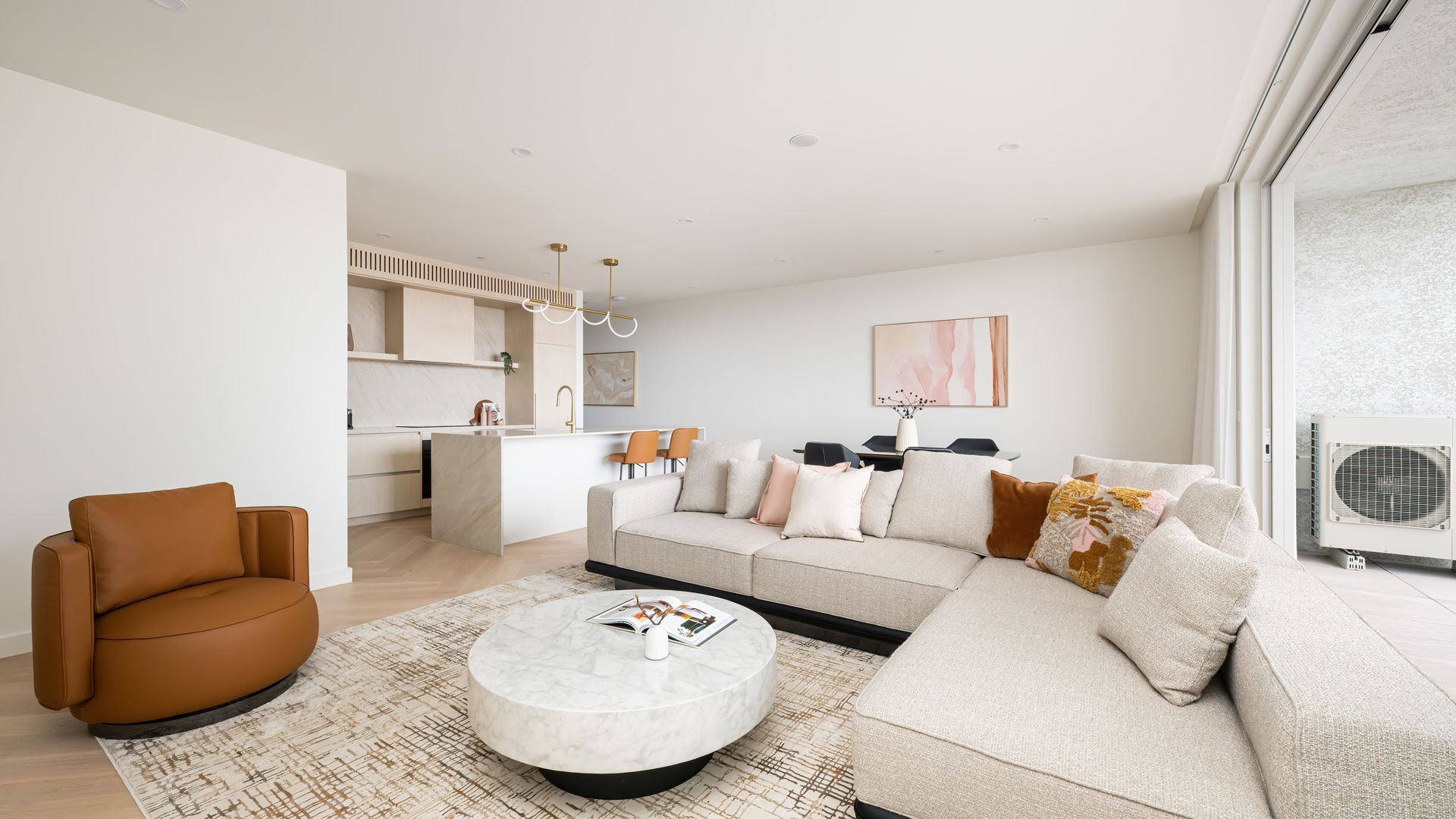 A modern living room with a sofa, a coffee table, and a brown leather chair.