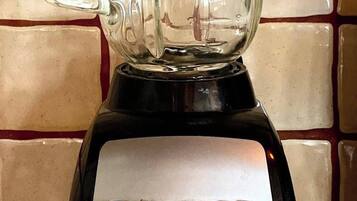 A kitchen blender with a clear pitcher and a black base, placed on a tiled countertop.