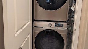 Une buanderie équipée de deux machines à laver Samsung superposées.