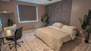 Une chambre à coucher comprenant un lit, un bureau, une chaise, un ventilateur de plafond et une fenêtre.