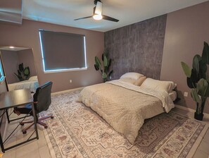 A bedroom with a bed, a desk, a chair, a ceiling fan, and a window. - Cozy 2-bedroom condo in charming Rancho Cucamonga (Rancho Cucamonga)