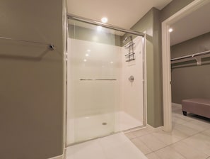 A glass-enclosed shower with a towel rack, a toilet, and a bench in a bathroom with tiled flooring. - Cozy 2-bedroom condo in charming Rancho Cucamonga (Rancho Cucamonga)