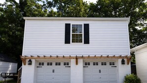 A two-story building with a garage and a small window with shutters. - NEW Luxury Carriage House Downtown Somerset (Somerset)
