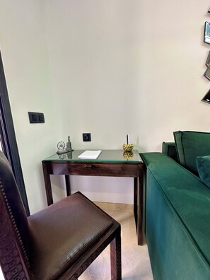 A room with a wooden desk, a green sofa, and a leather chair. - Cozy Studio with Pool View & 4 Pools – Near Gueliz (Marrakech)